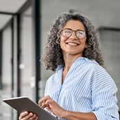 Woman smiling while holding tablet in office