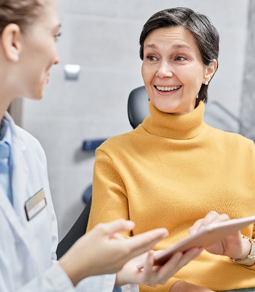 a patient smiling while talking with her dentist