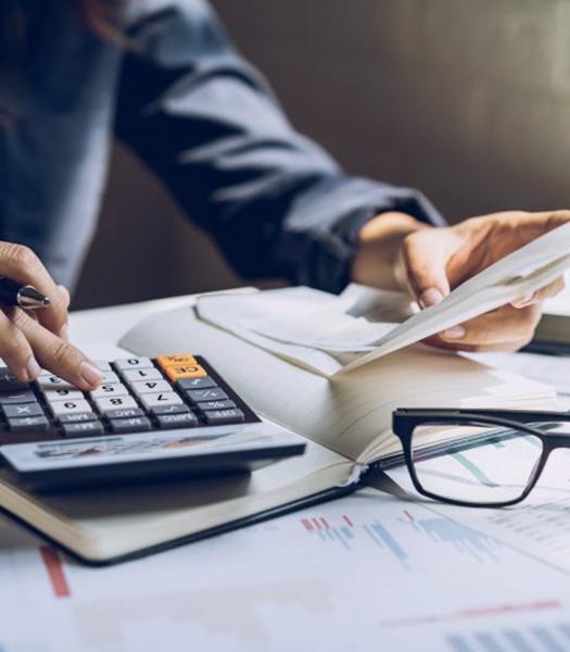 Individual using a calculator at their desk