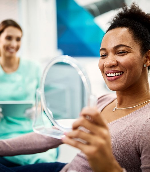 a dental patient looking in a handheld mirror