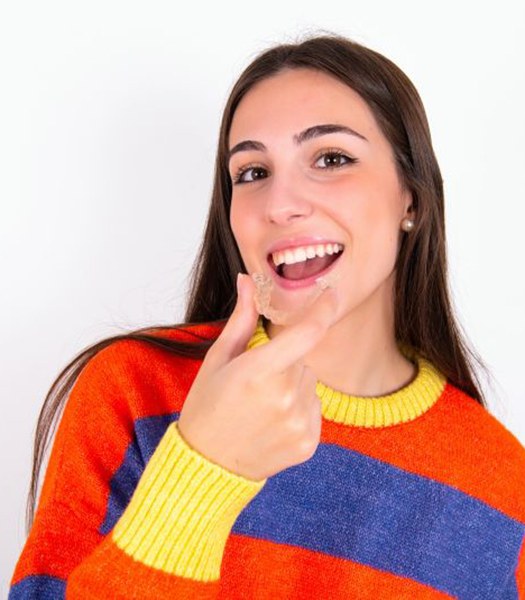 Teen girl holding a clear aligner