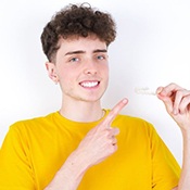 Teen boy pointing to his clear aligner