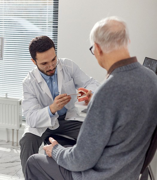 Older man paying attention to dentist’s instructions