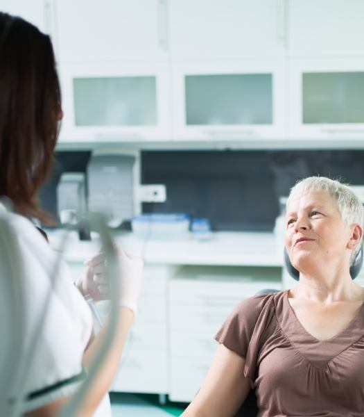 Dentist and patient discussing the four step dental implant process