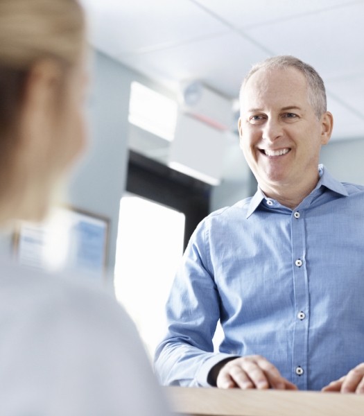 Man discussing how dental insurance works with dental team member