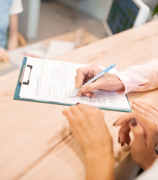 Dental patient completing dental insurance forms