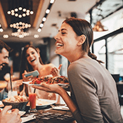 a woman with dentures enjoying a meal with friends