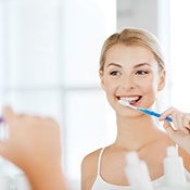 Young woman brushing her teeth at home