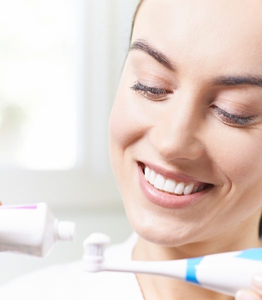 Woman brushing teeth to prevent dental emergencies