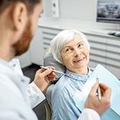 Older woman smiling at her implant dentist in Rancho Park