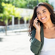 Woman smiling while talking on phone outside