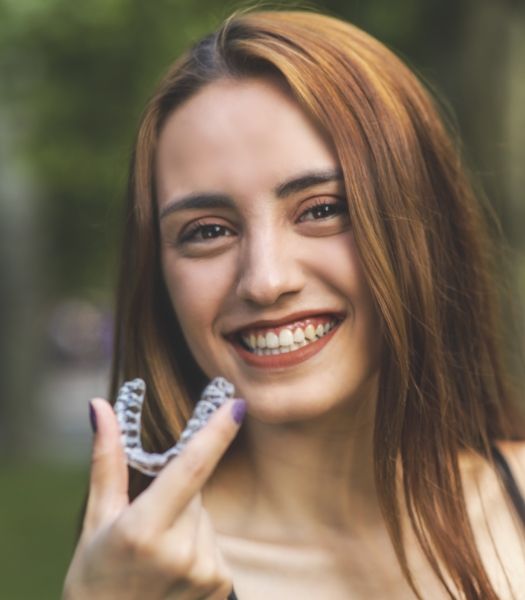 Woman placing clear correct orthodontics tray