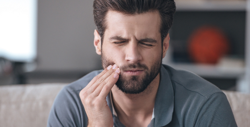 Man holding cheek before restorative dentistry