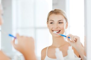 Woman looking in mirror to brush her teeth