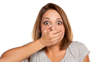Woman with hand over mouth after losing a dental filling
