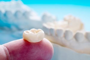 a person holding a dental crown 