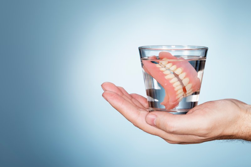 Dentures soaking in a glass of water