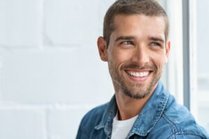 Man smiling after his orthodontic treatment with a straighter teeth