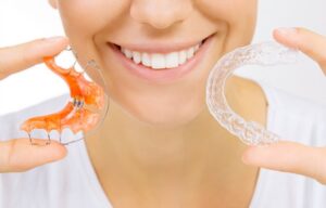 Woman holding two retainers.