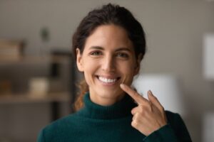 Woman smiling and pointing to her teeth